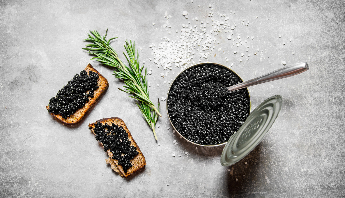 Beluga caviar alternative made from eggs in a tin with toast and a sprig of rosemary