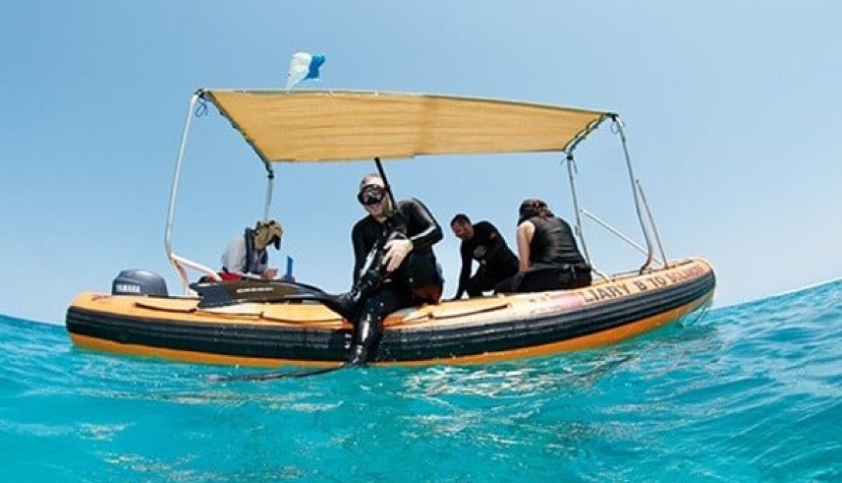Robert Harcourt prepares to dive, retrieving data from acoustic receivers on a boat in the ocean