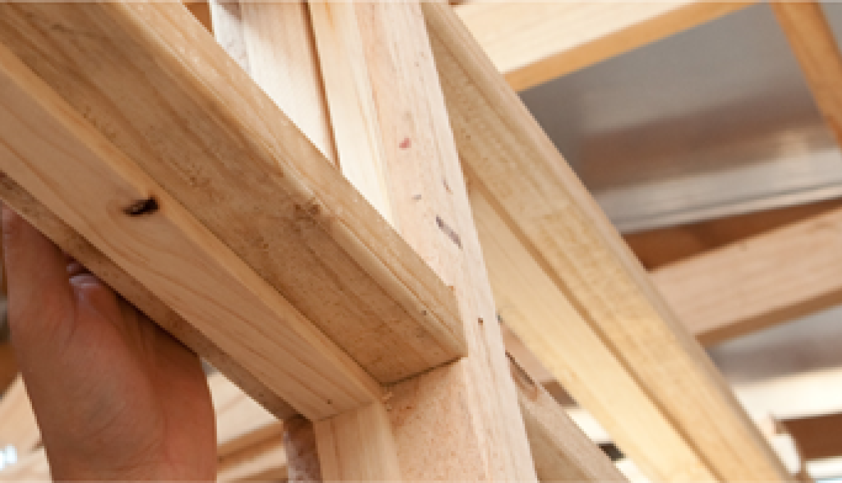Close up image of a hand touching a internal wooded frame work